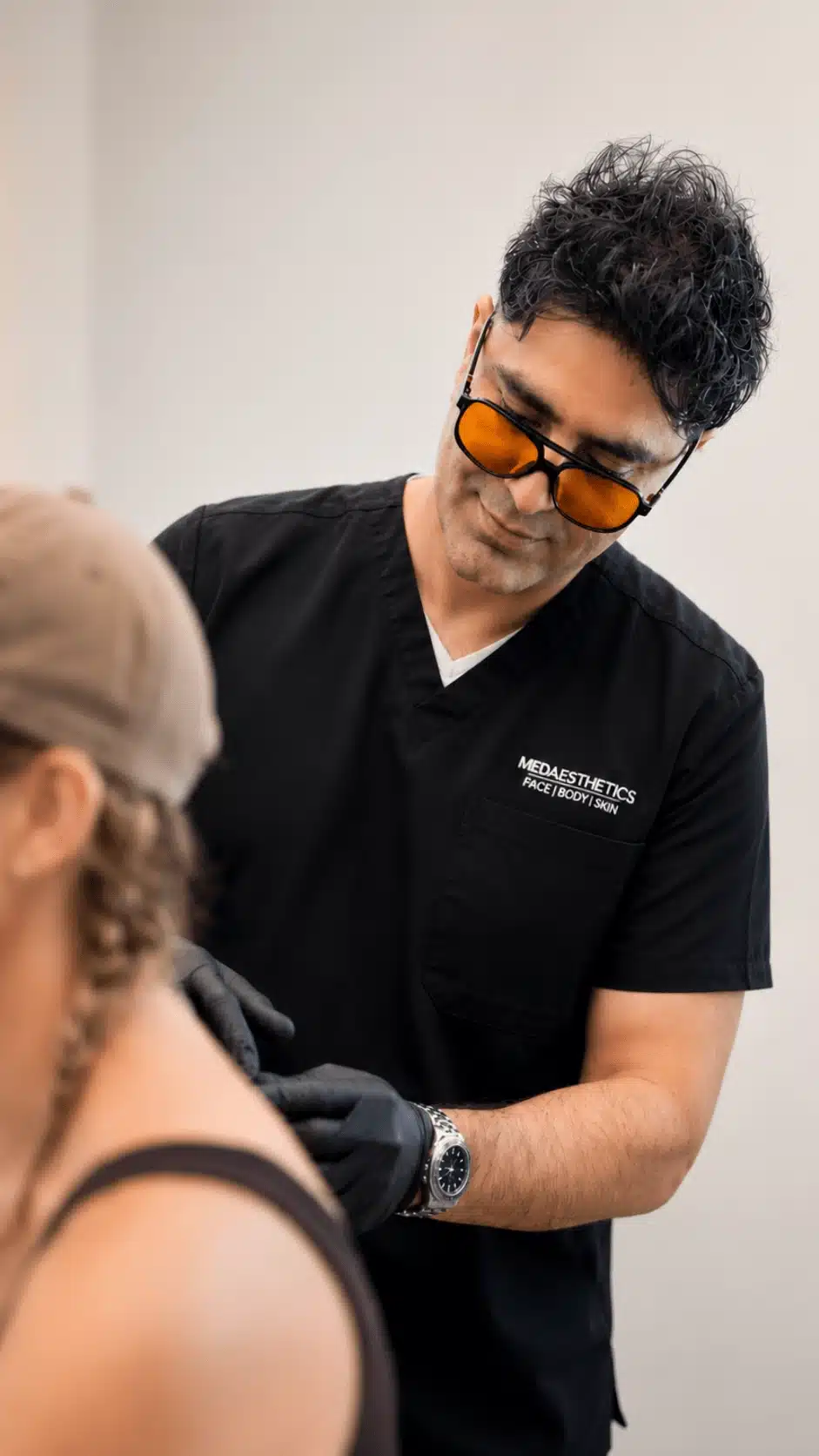 Dr Ehsan Jadoon examining a patient's shoulder before laser mole removal
